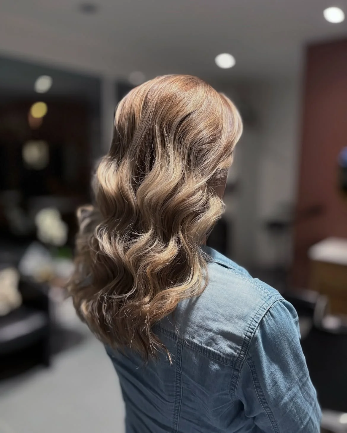 Balayage caramel sur cheveux longs ondulés réalisé au salon LM Coiffure à Audenge