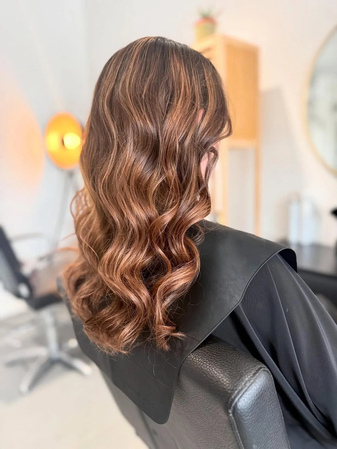 Balayage cuivré sur cheveux longs ondulés réalisé au salon LM Coiffure à Audenge