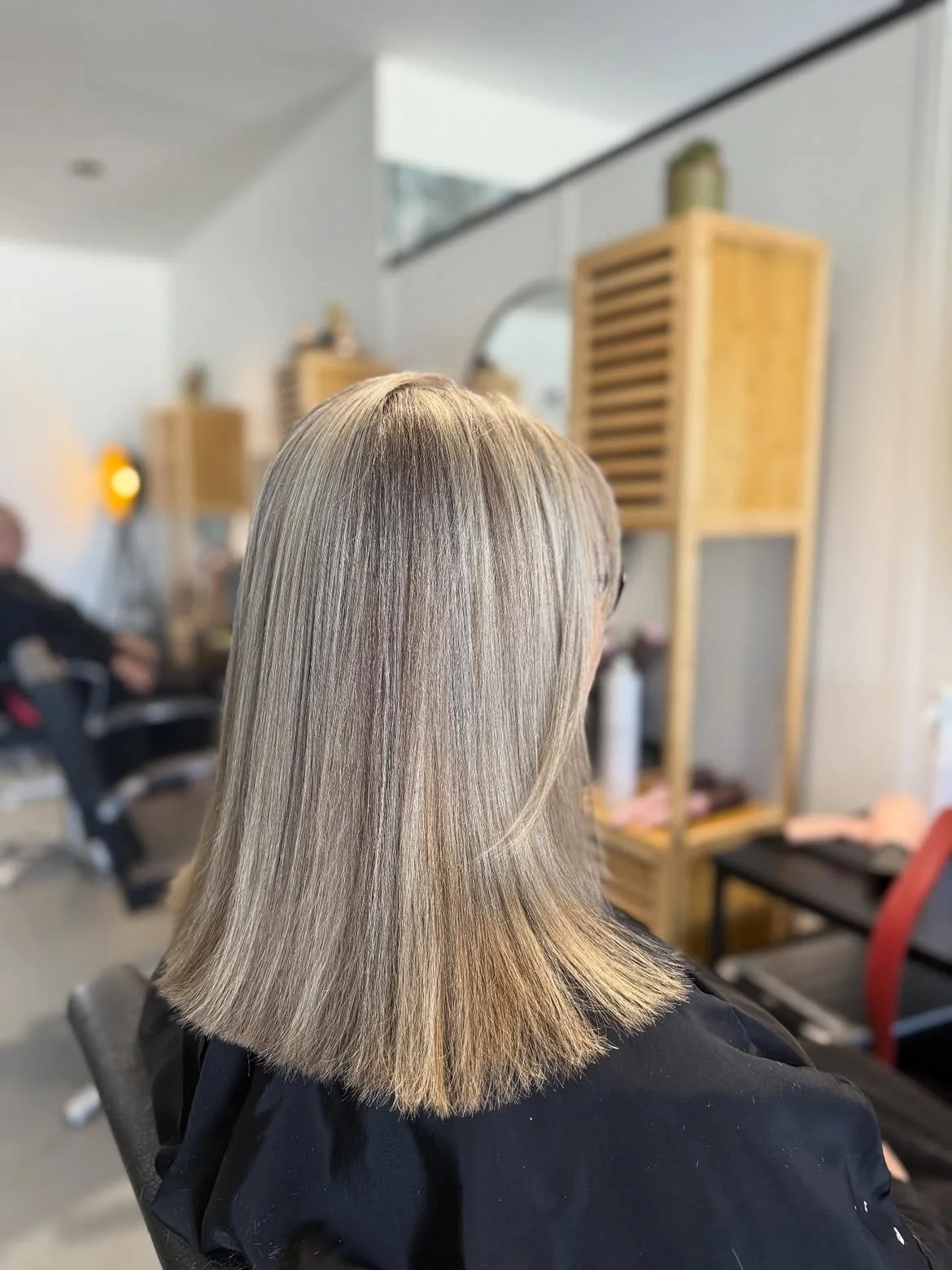 Mèches blond cendré sur carré long lissé réalisées au salon LM Coiffure à Audenge